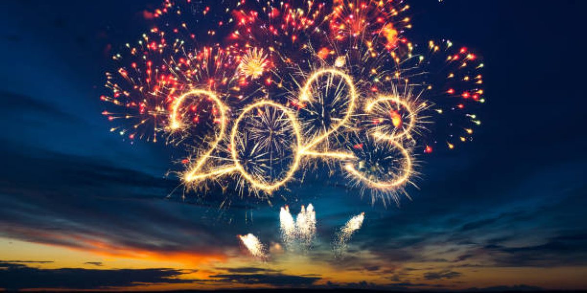 Happy New Year 2023. Beautiful creative holiday web banner or flyer with red fireworks and Golden sparkling number 2023 on blue sky  over sea